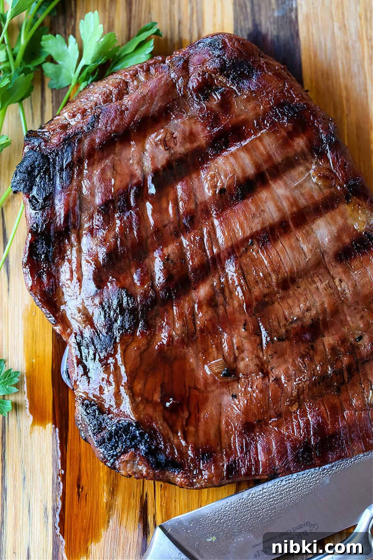 grilled flank steak resting on board