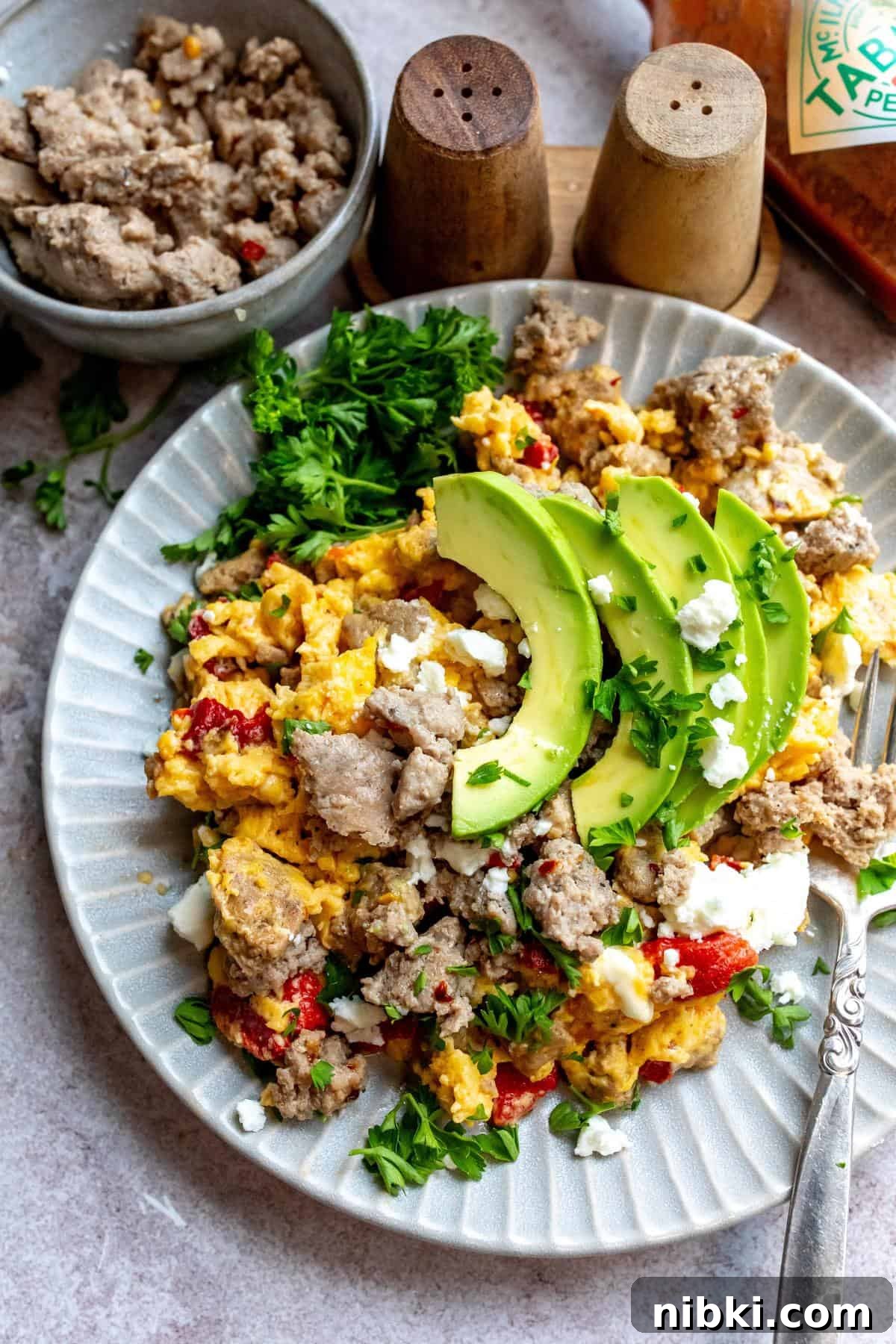 Homemade Turkey Sausage with Garlic and Fresh Herbs 2 An image of turkey sausage on a plate with eggs, avocados, and veggies.