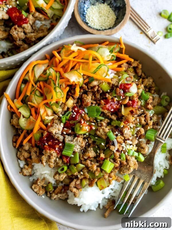 Ground turkey with sauce and veggies in a grey bowl.