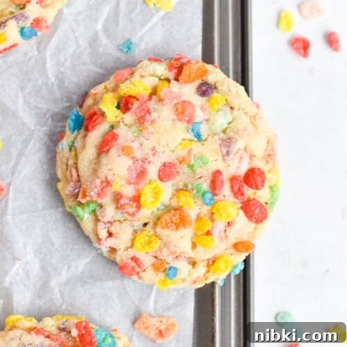fruity pebble cookie on edge of baking sheet.