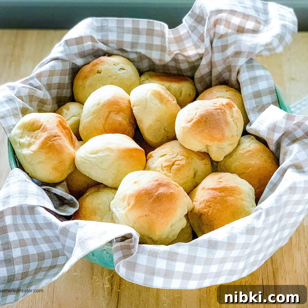 Sourdough rolls on a kitchen towel wrapped bowl.
