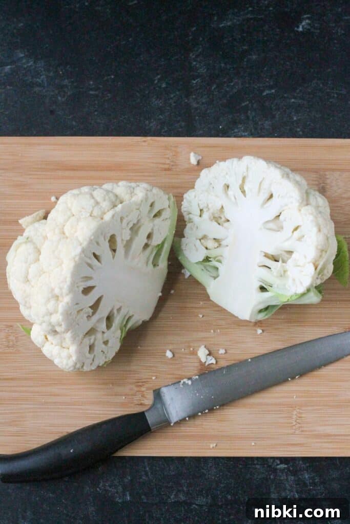 How to Make Crispy Vegan Roasted Cauliflower Steaks 5 A head of cauliflower cut in half.