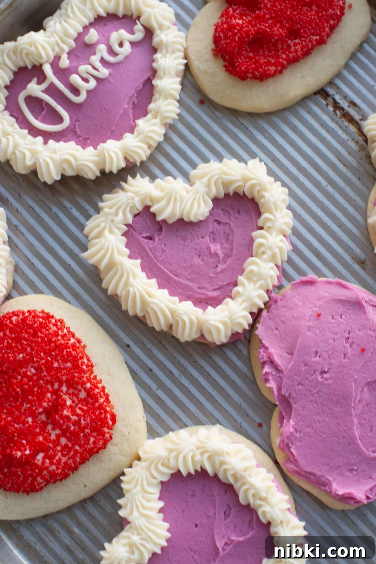No-Chill Soft Sugar Cookies That Stay Tender and Chewy 13 Frosted sugar cookies on a baking sheet.
