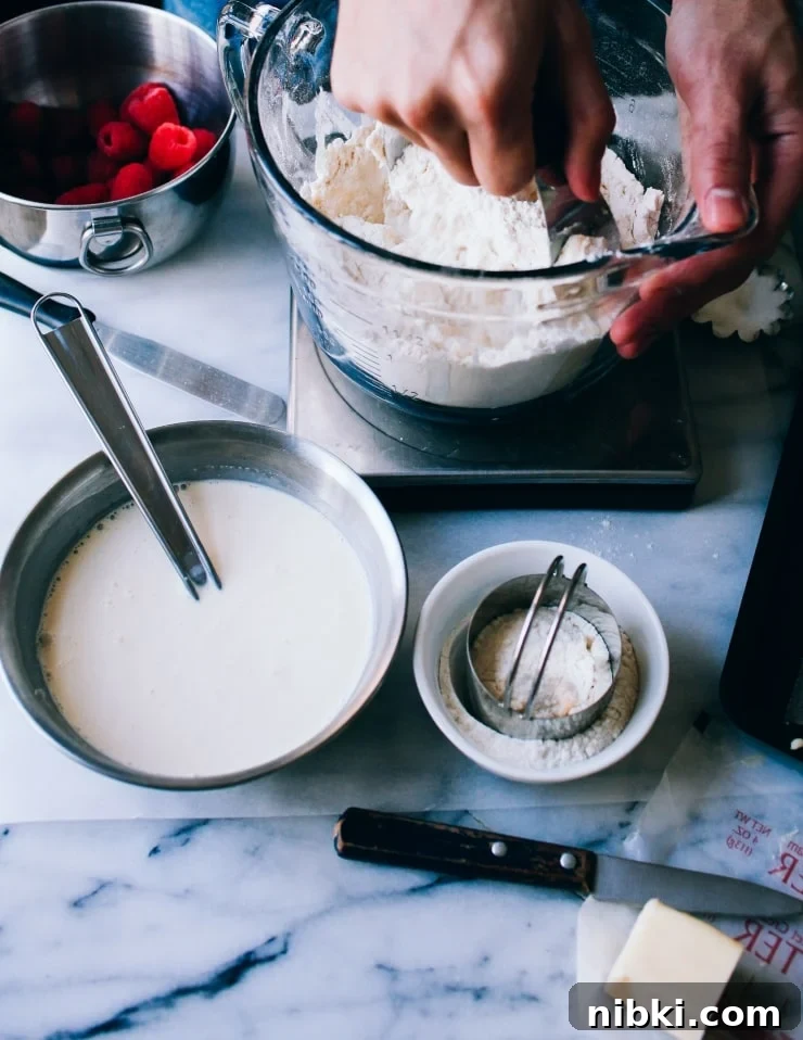 Flaky Homemade Raspberry Scones with Lemon Glaze 3 Cutting butter into flour | sophisticatedgourmet.com
