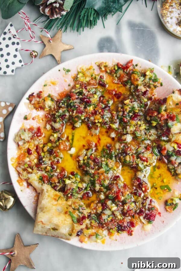 Festive dipping oil in a small pink plate on a grey surface.
