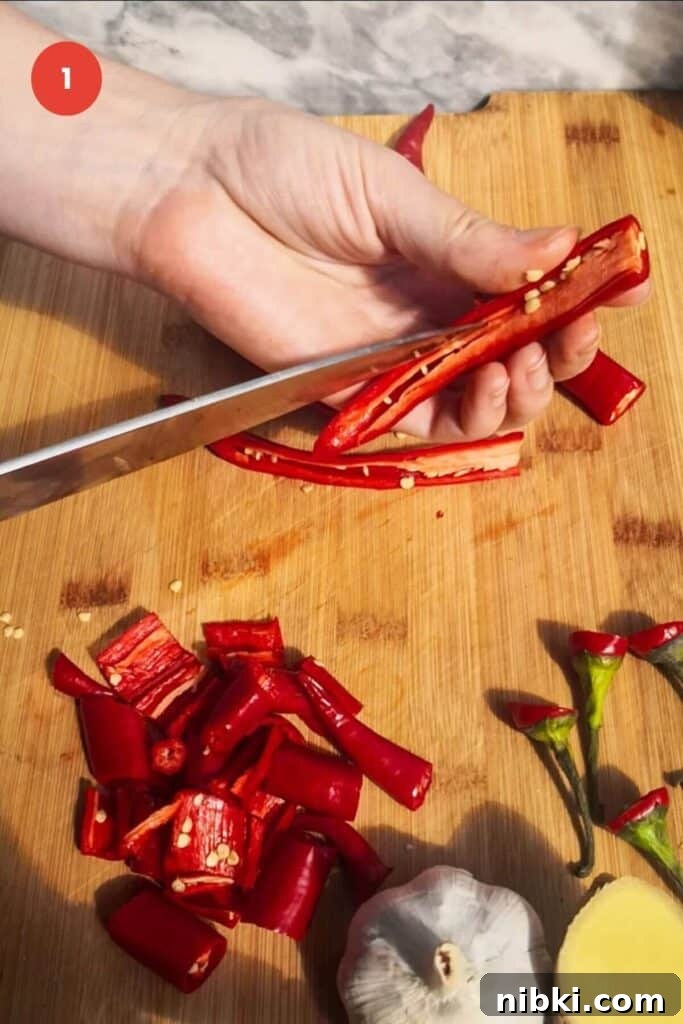 30-Minute Sweet Chili Jam Recipe 3 Slicing red chilies on chopping board.