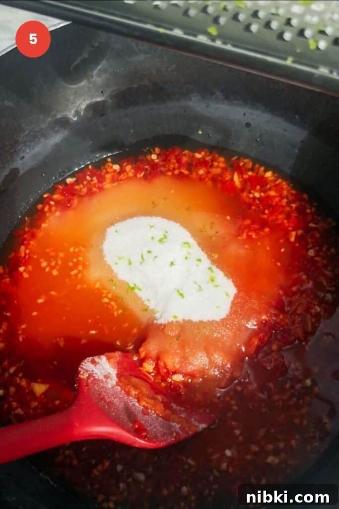30-Minute Sweet Chili Jam Recipe 7 Chili jam ingredients in a pot with sugar and lime zest.