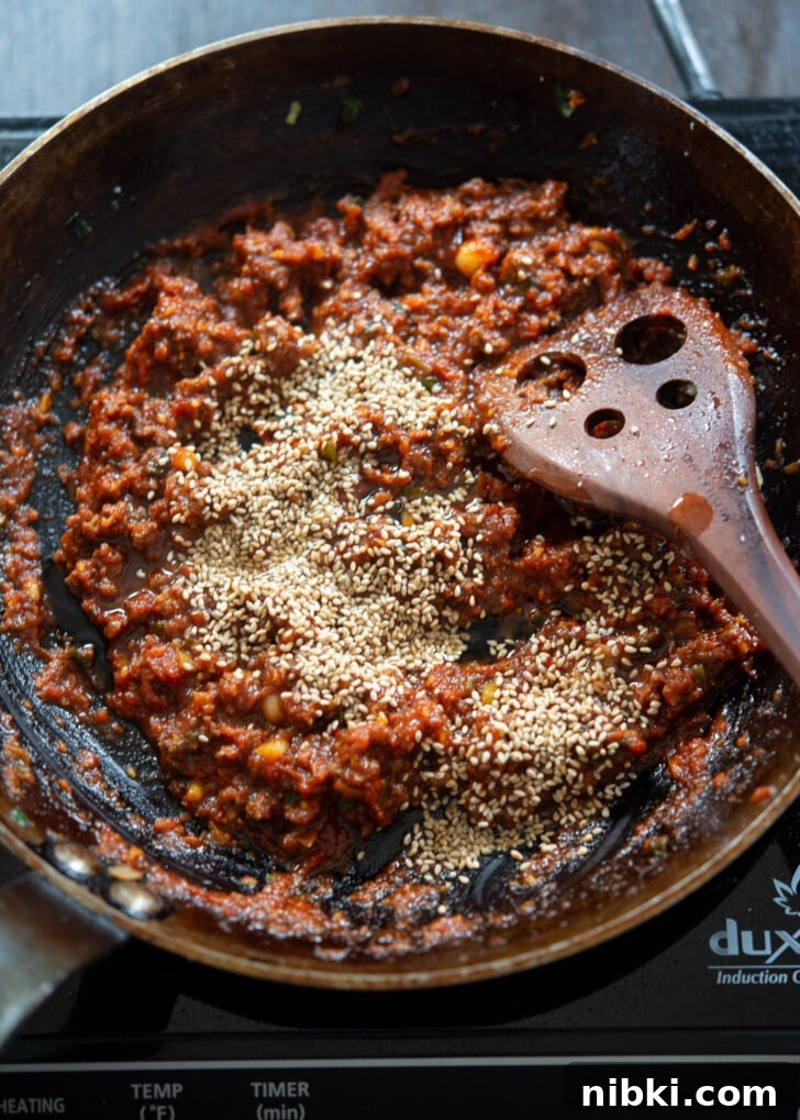20-Minute Beef Noodles with Gochujang Sauce 10 Sesame oil and sesame seeds are added to beef gochujang noodle sauce in a skillet