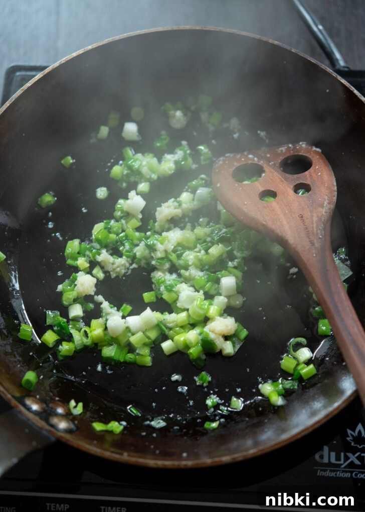 20-Minute Beef Noodles with Gochujang Sauce 6 Green onion and garlic frying in a skillet.