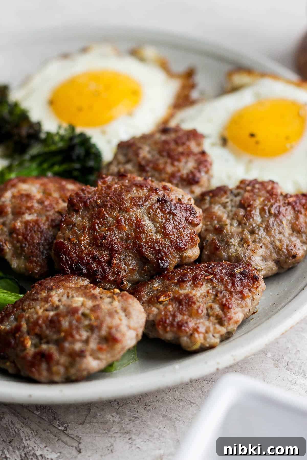 Another view of the sausage on a plate with eggs.