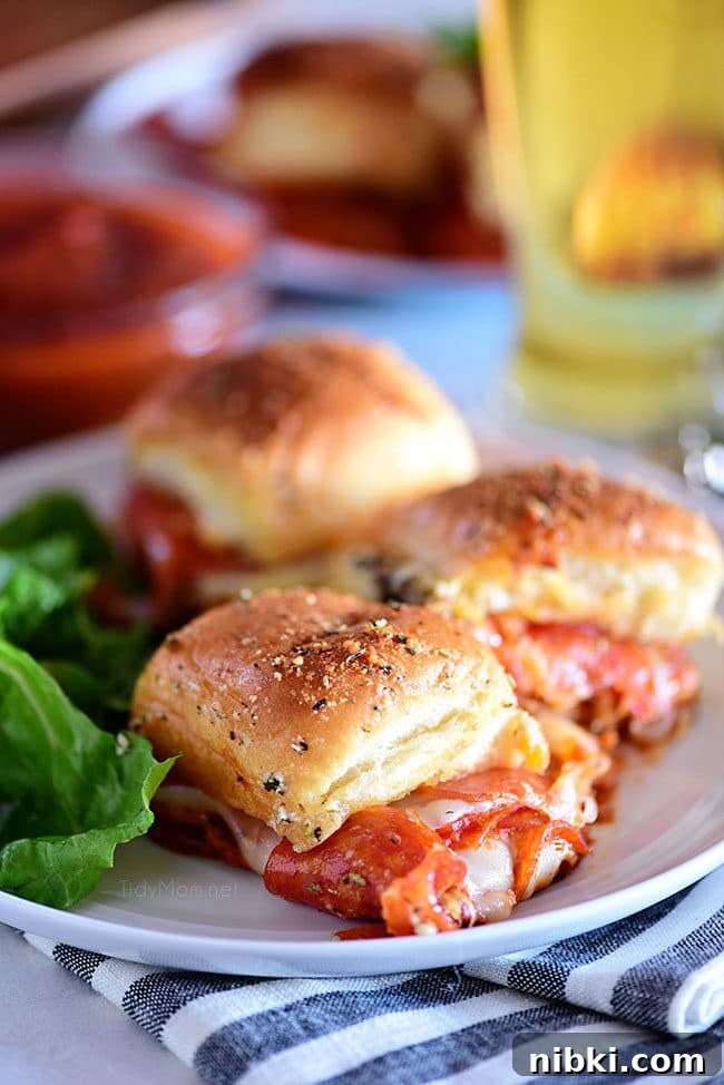 Cheesy pepperoni sliders three cheesy pepperoni Pizza Sliders on a plate