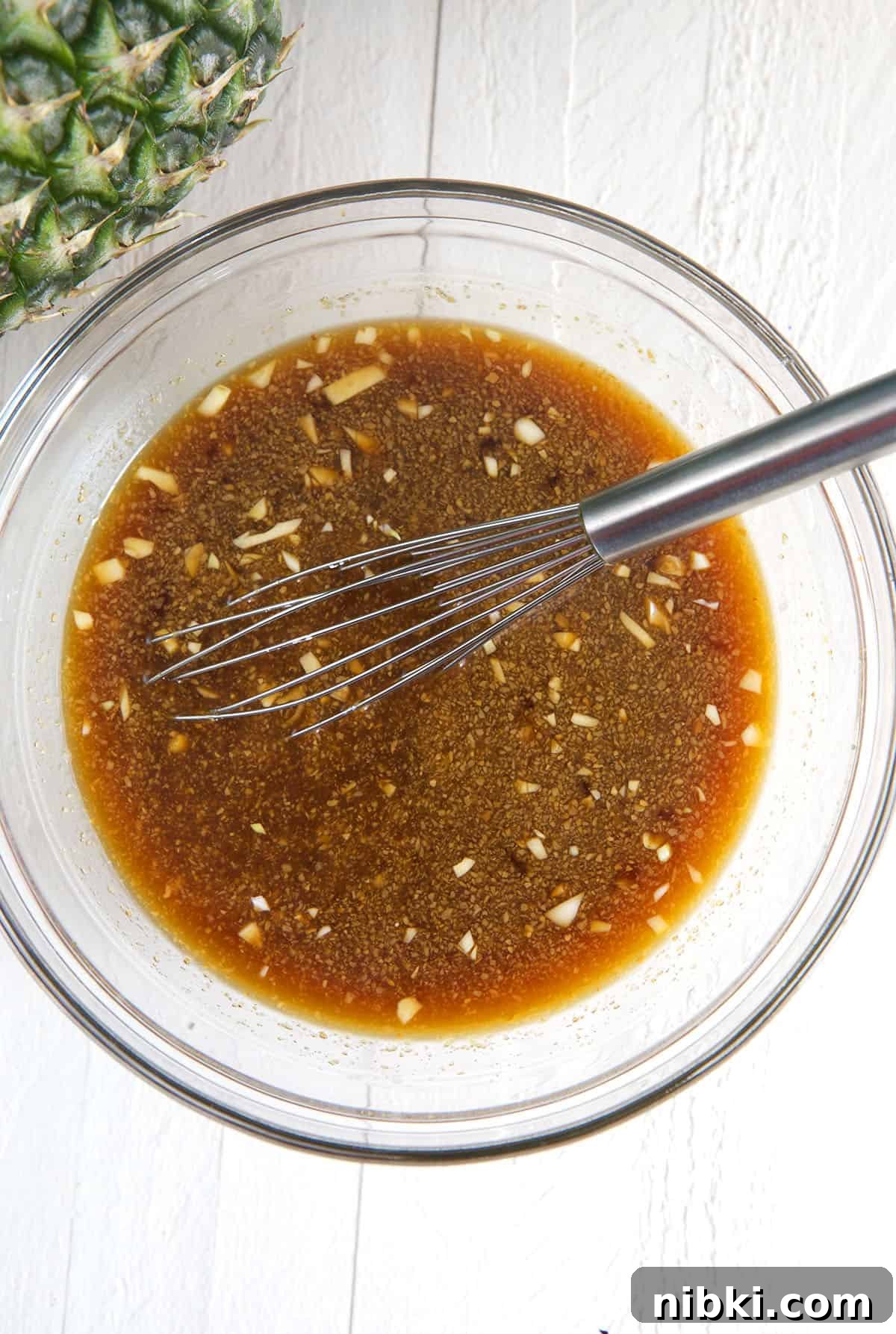 A bowl of sauce is being whisked.