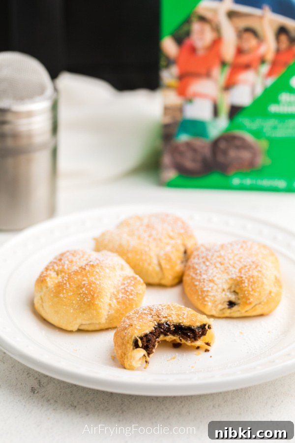 Air Fried Thin Mints on a white plate and topped with powdered sugar. 