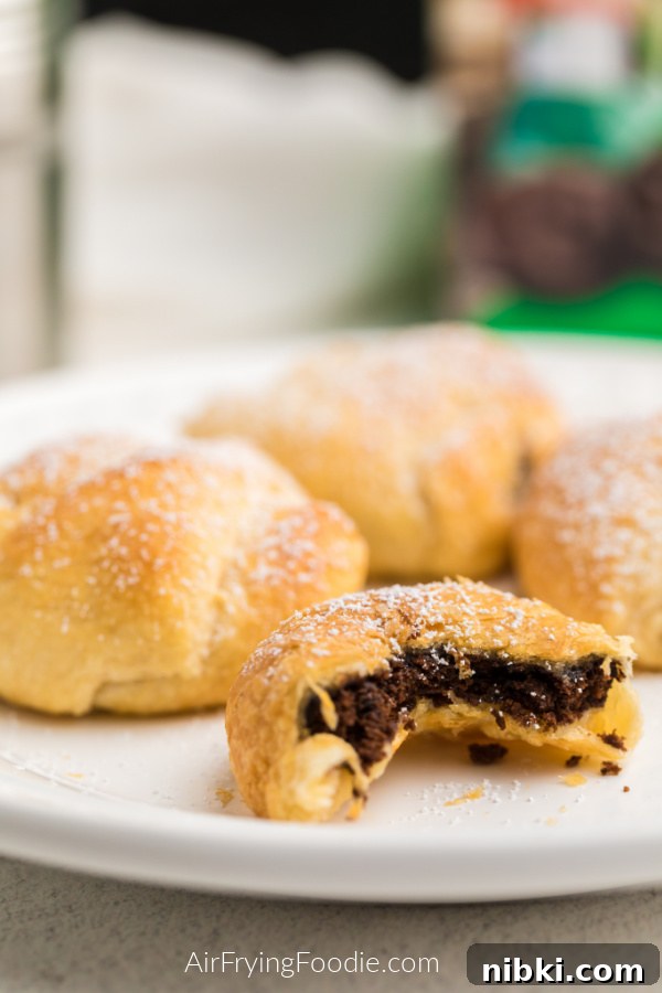 Close up of Air Fryer Thin Mints on a white plate with one that has a bite taken out of it. 