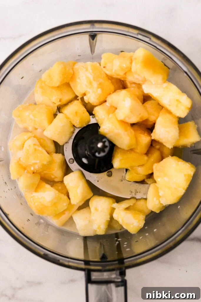 Copycat Disney Pineapple Dole Whip Recipe 3 Ingredients added to food processor for blending pineapple Dole Whip