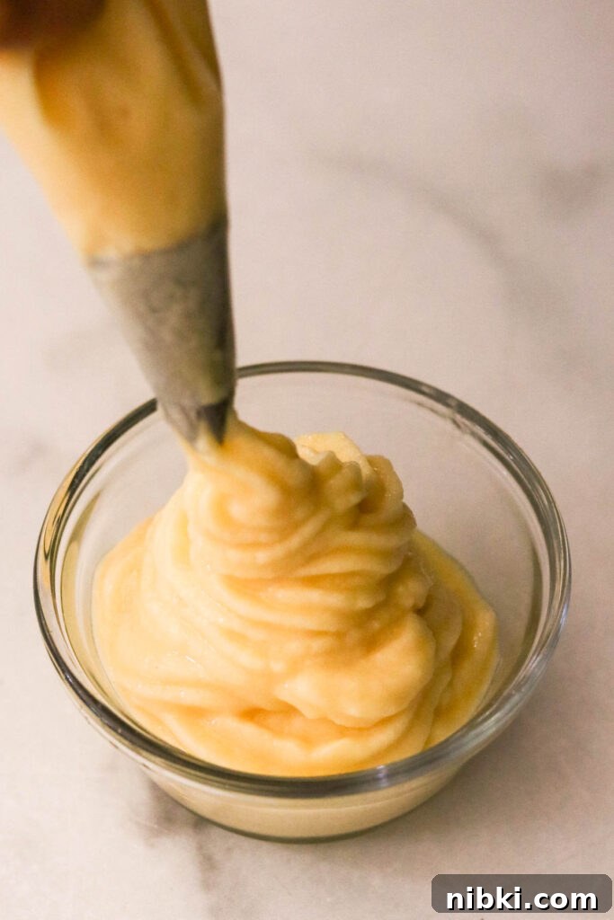 Copycat Disney Pineapple Dole Whip Recipe 5 Pineapple Dole Whip piped into a swirl in a glass bowl
