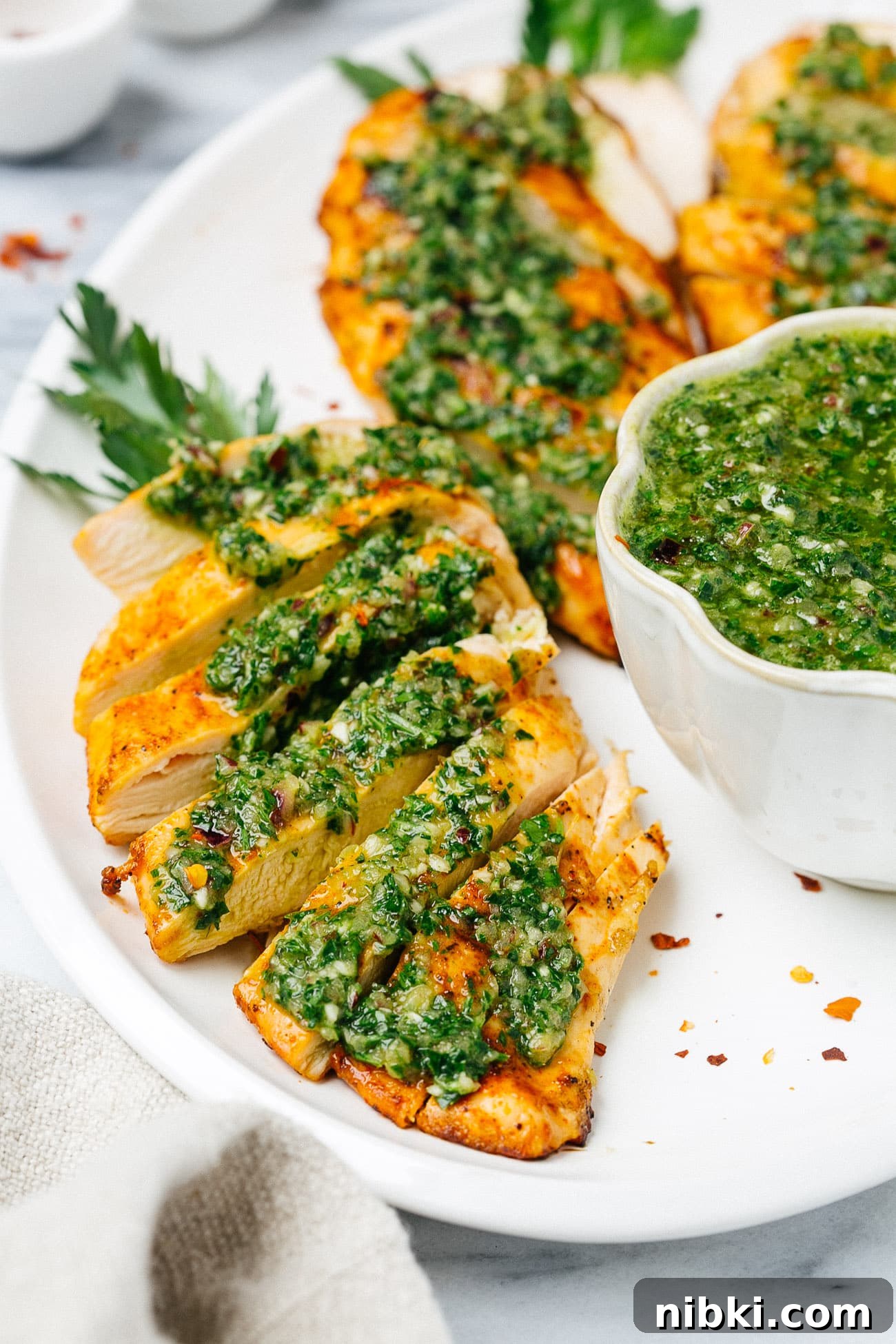 Juicy Grilled Chicken with Chimichurri Recipe 6 overhead chicken breast with chimichurri sauce on a white plate
