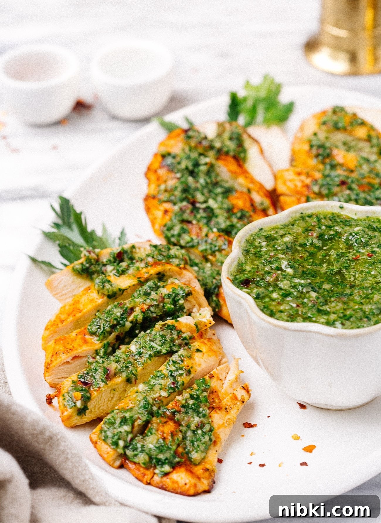 Juicy Grilled Chicken with Chimichurri Recipe 7 overhead chicken breast with chimichurri sauce on a white plate