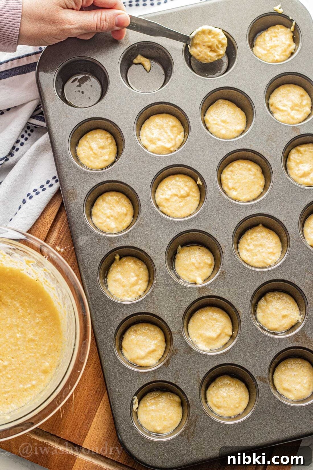 Crispy Mini Corn Dogs Recipe 5 spooning corn batter into muffin pan with spoon.