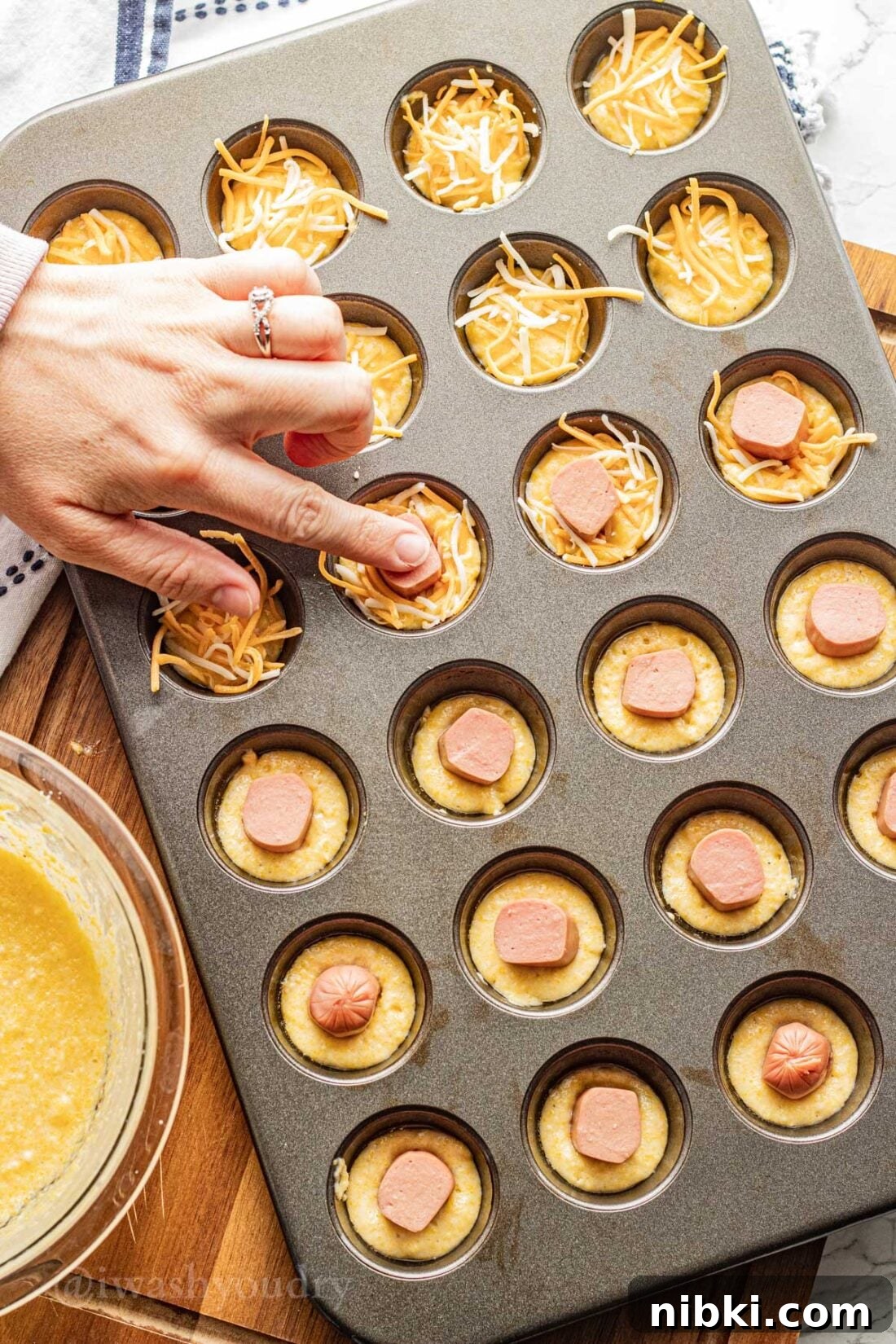 Crispy Mini Corn Dogs Recipe 6 adding hot dogs and cheese to corn dog batter.