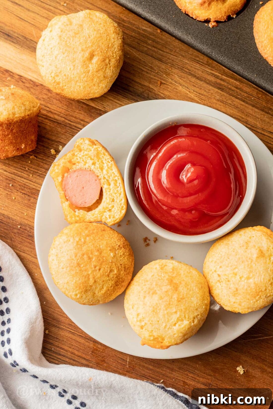 Crispy Mini Corn Dogs Recipe 8 Mini Corn Dog Nuggets on a plate with a bowl of ketchup.