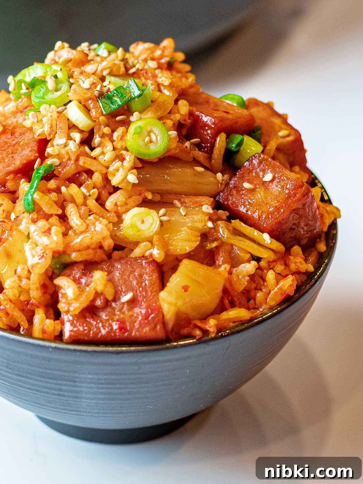 Spicy Kimchi Fried Rice with Crispy Spam 6 bowl of kimchi fried rice with spam topped with scallions and sesame seeds