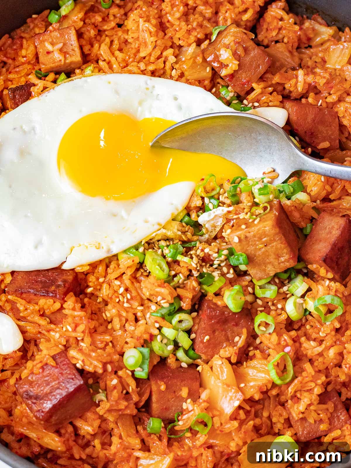 Spicy Kimchi Fried Rice with Crispy Spam 3 kimchi fried rice with spam topped with a sunny side up egg with a spoon