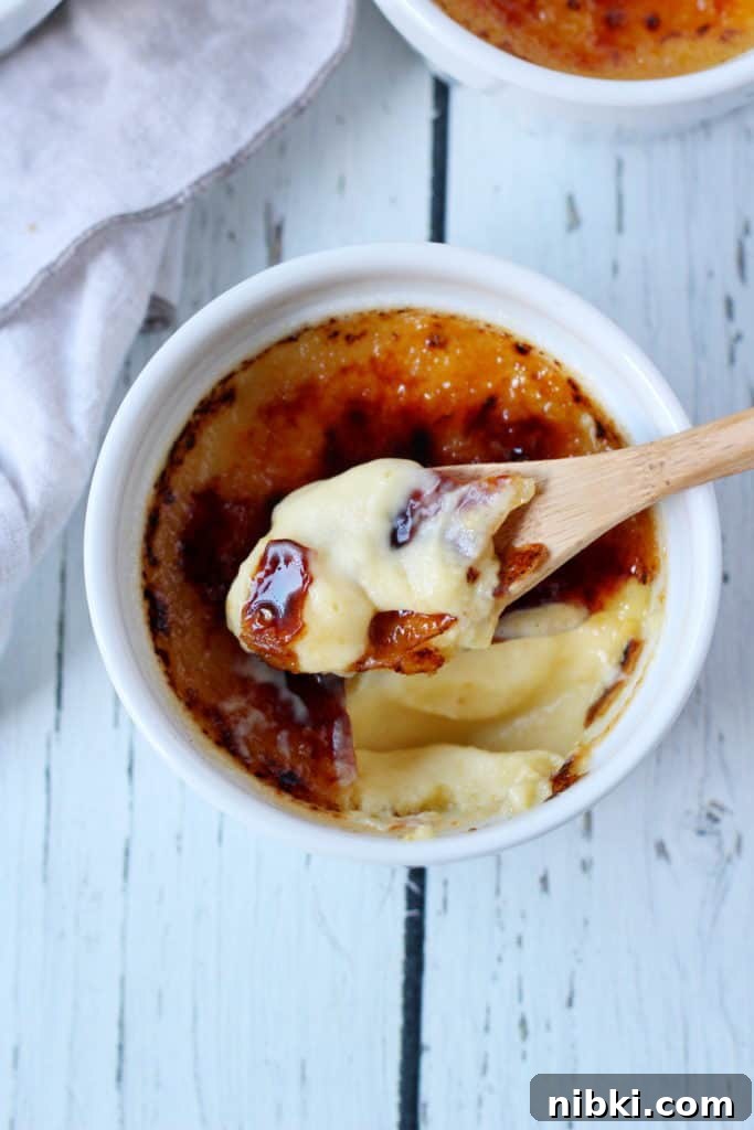 creme brule in ramekin with spoon taking first bite