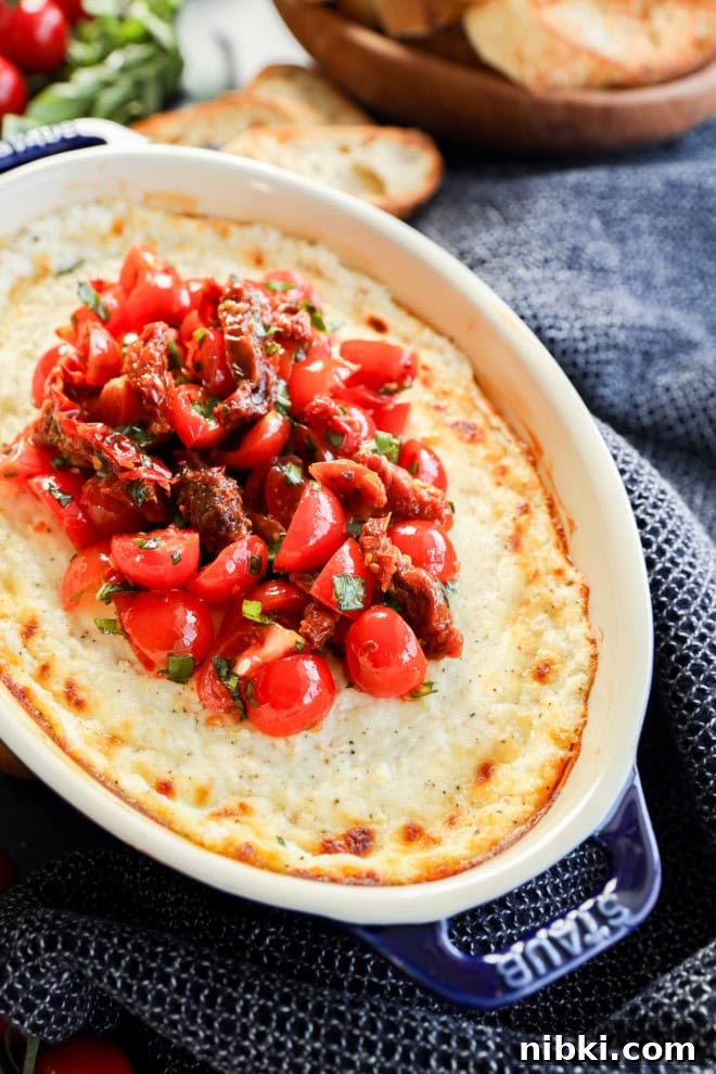 baked goat cheese appetizer in baking dish with tomato topping