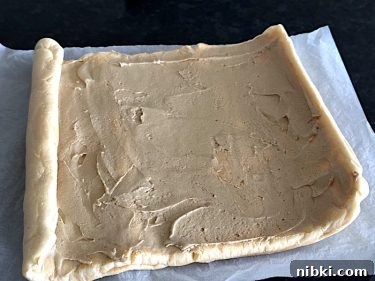 Bowl of coffee filling beside a rolled sponge sheet, prep for a keto carnivore coffee Swiss roll.