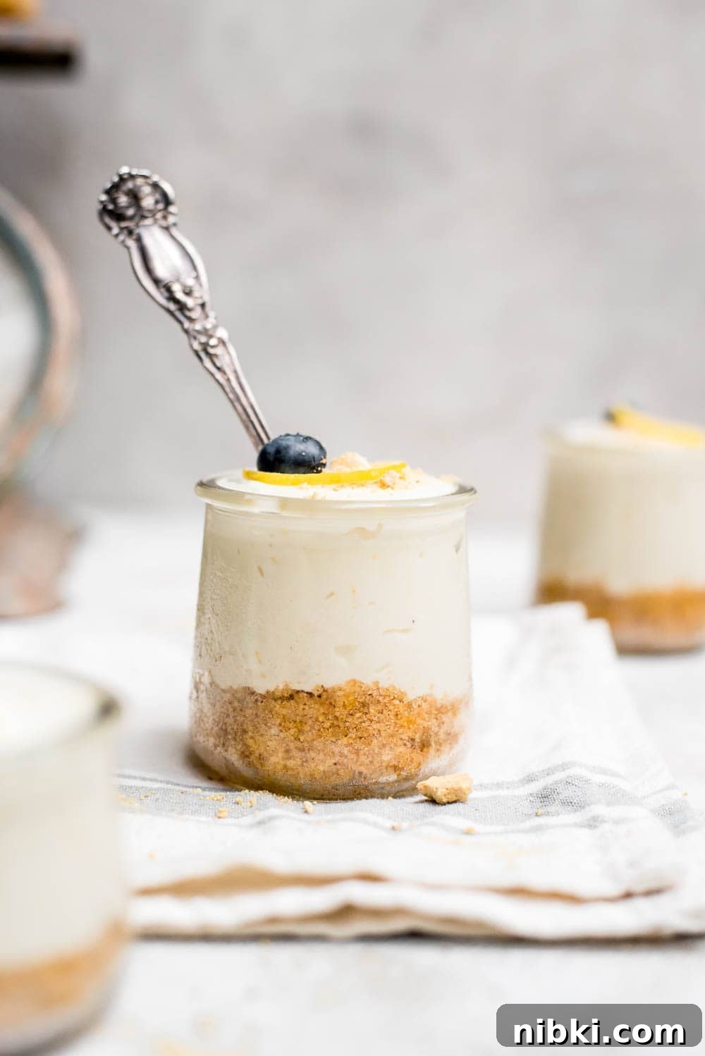 no bake lemon cheesecake in a jar on kitchen towel with spoon