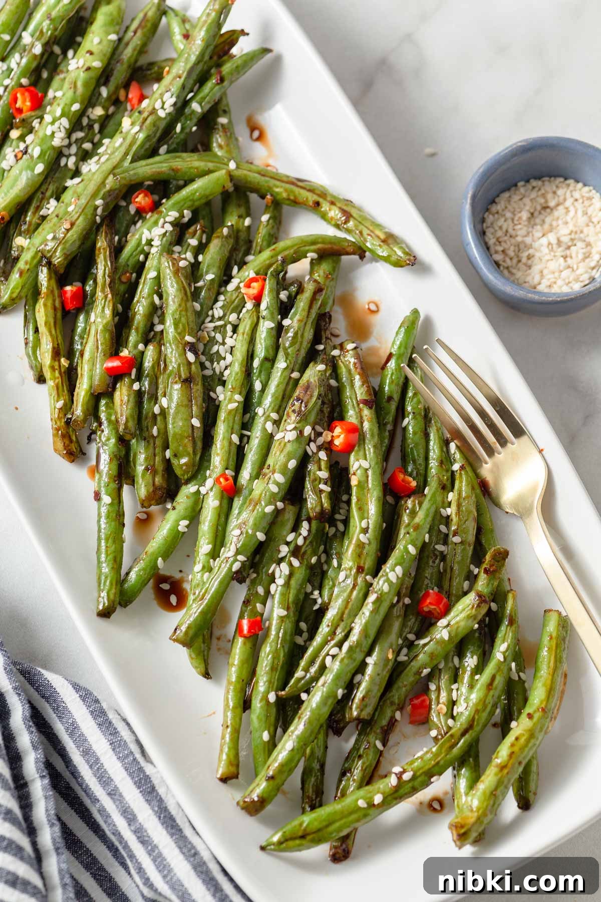 air fryer asian green beans on a plate with a fork.