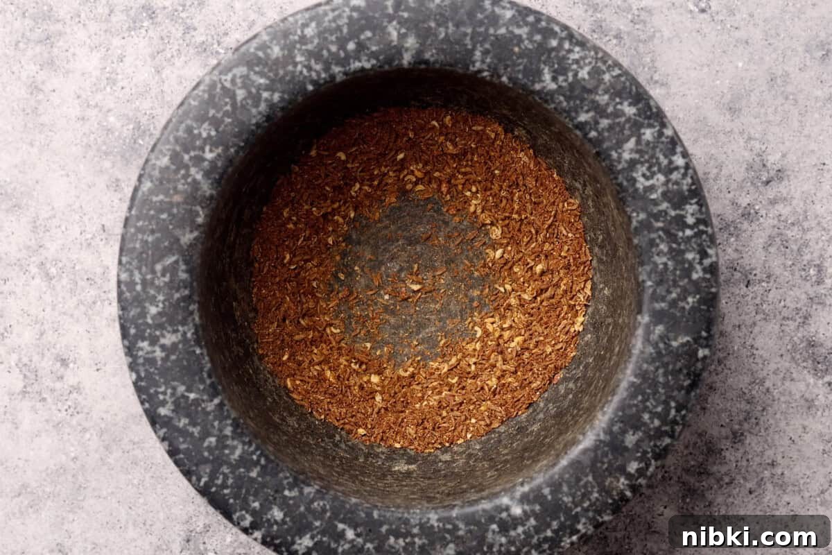 Cumin-Spiced Lamb Recipe: Tender, Flavorful Roast 6 A mortar with ground brown spices
