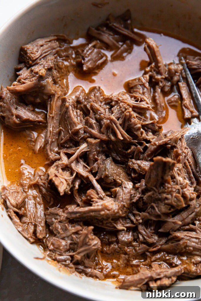 Instant Pot Barbacoa Tacos 3 instant pot beef barbacoa in a bowl.