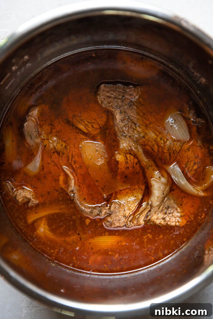 Instant Pot Barbacoa Tacos 6 barbacoa in an instant pot with broth.