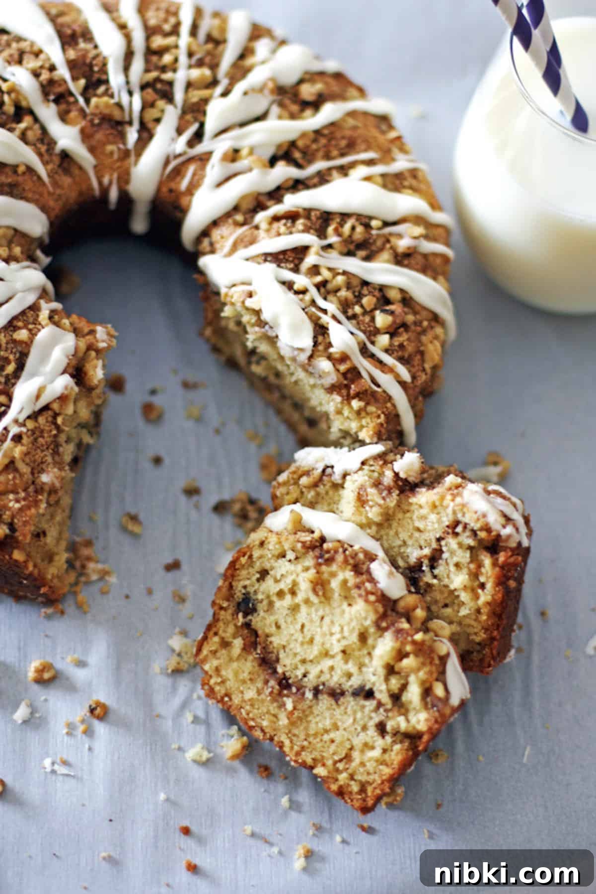 Moist Cinnamon Streusel Coffee Cake Recipe 2 Two slices of glazed cinnamon streusel coffee cake in front of the rest of the cake.