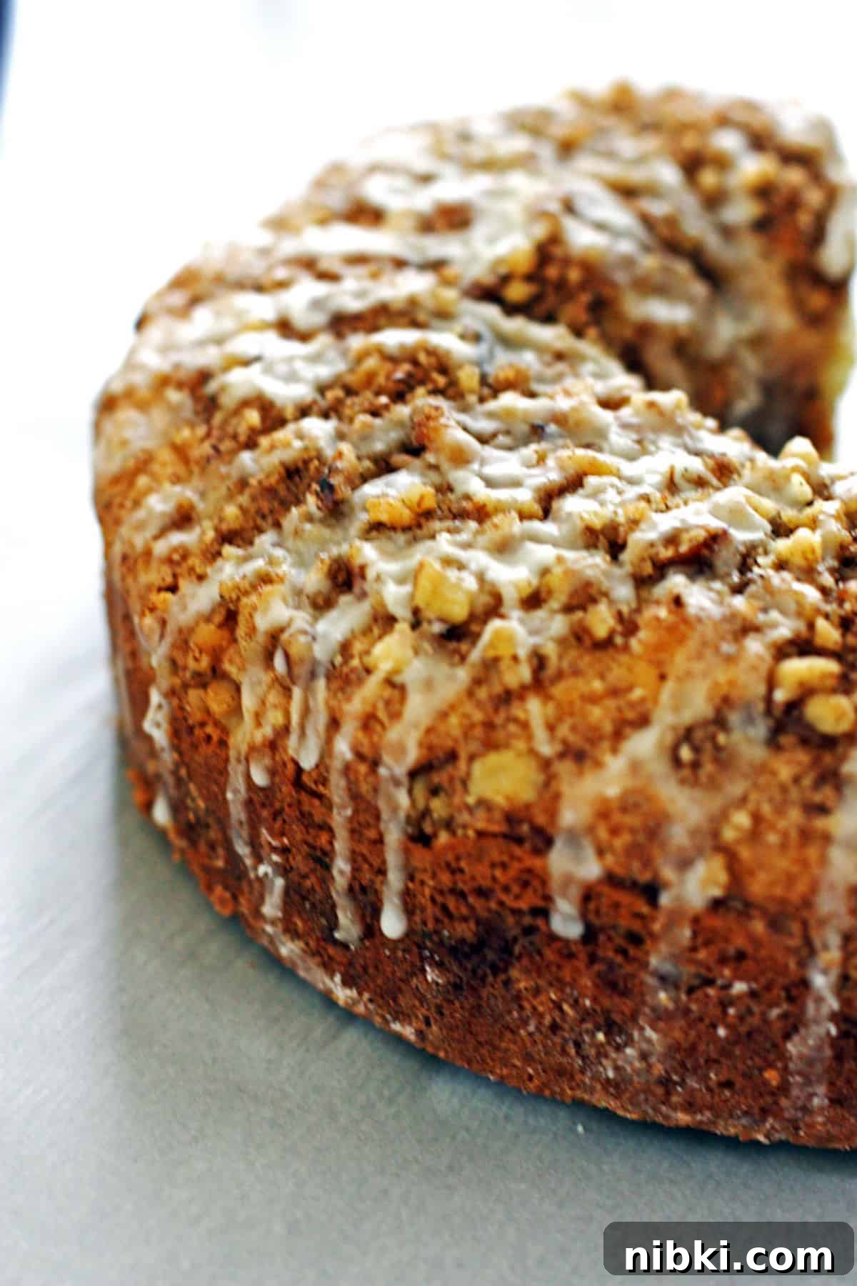 Moist Cinnamon Streusel Coffee Cake Recipe 5 A cinnamon streusel coffee cake from the side with glaze dripping down.