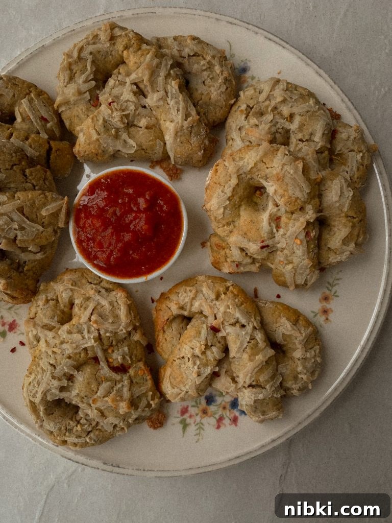 Gluten-Free Dairy-Free Soft Pizza Pretzels Without Yeast 3 soft pizza pretzels on a white floral plate with small bowl of marinara