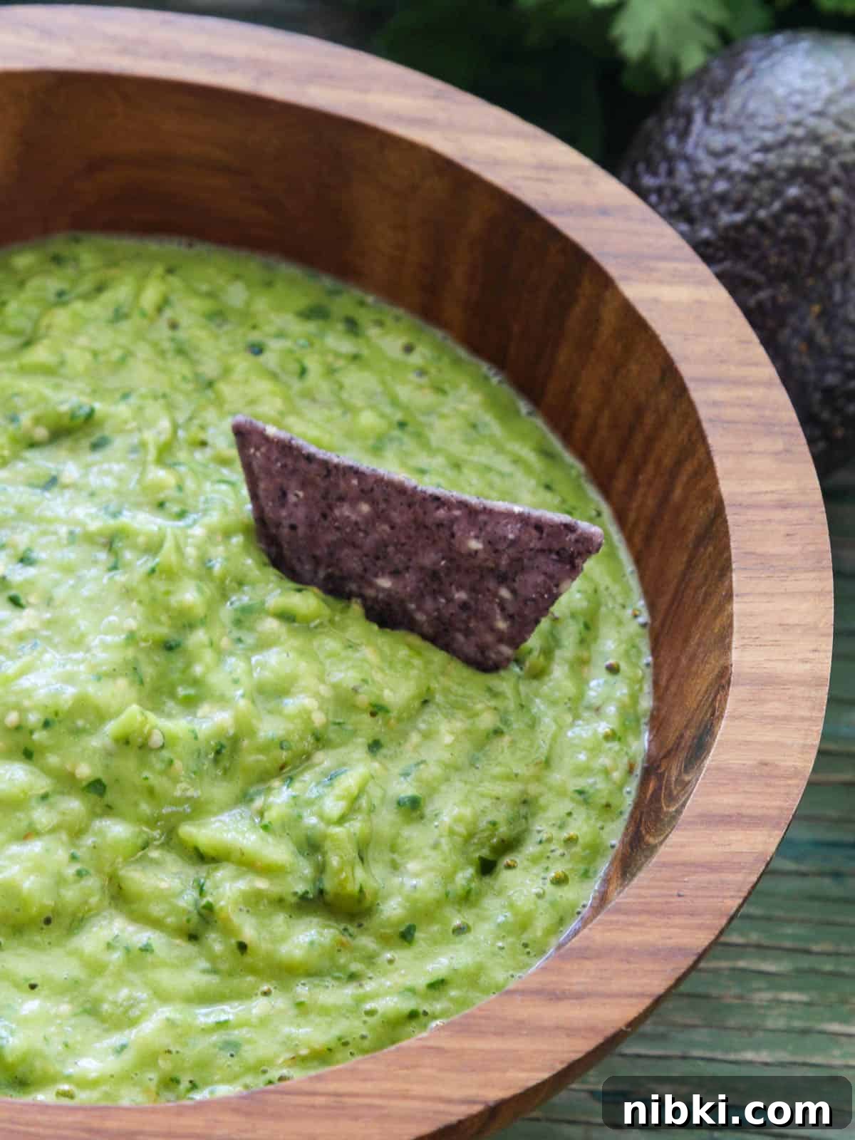 Bowl of Avocado Salsa with a blue corn chip