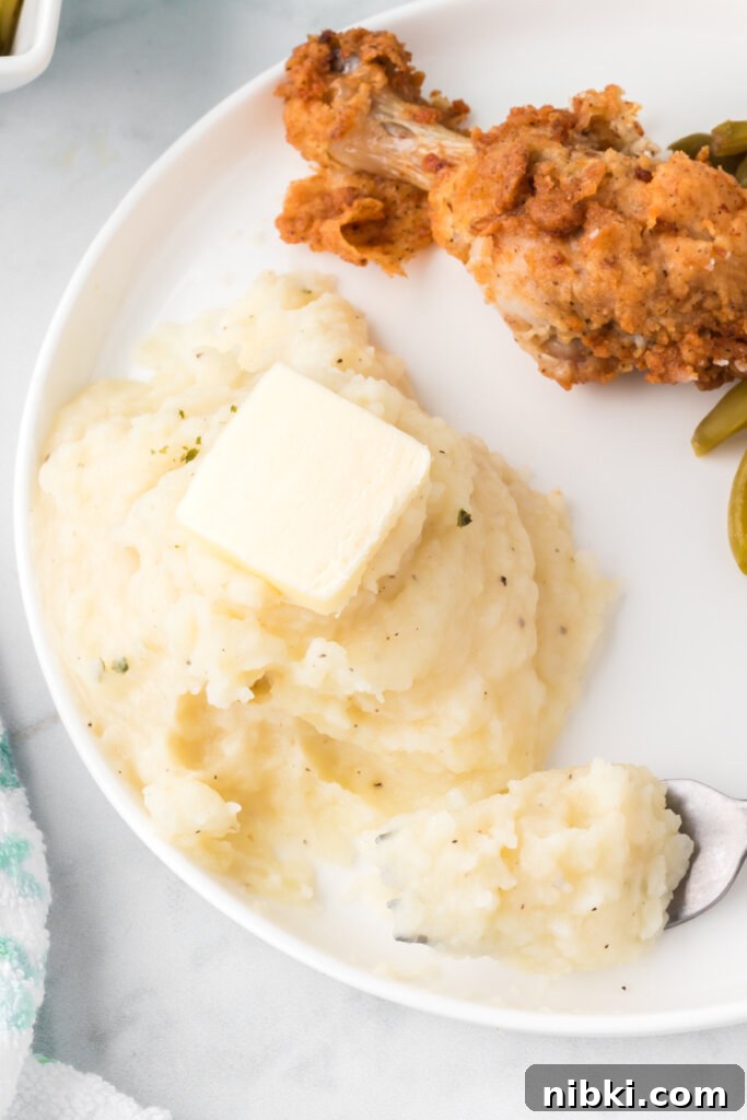 Creamy Garlic Butter Mashed Potatoes Recipe 3 mashed potatoes on plate with fork