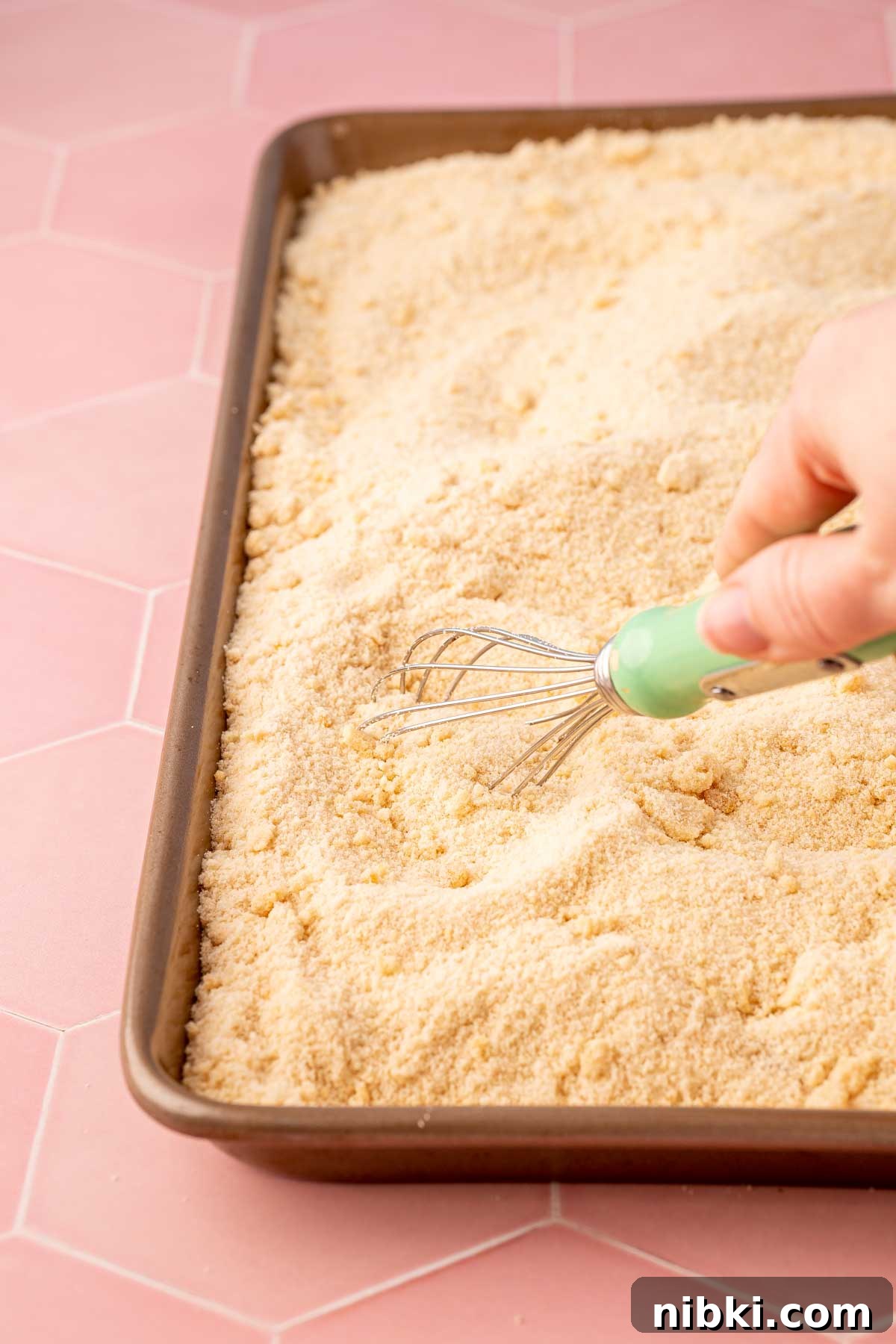 How to Make Toasted Sugar for Baking and Dessert Toppings 4 Toasted sugar being whisked on a baking sheet.