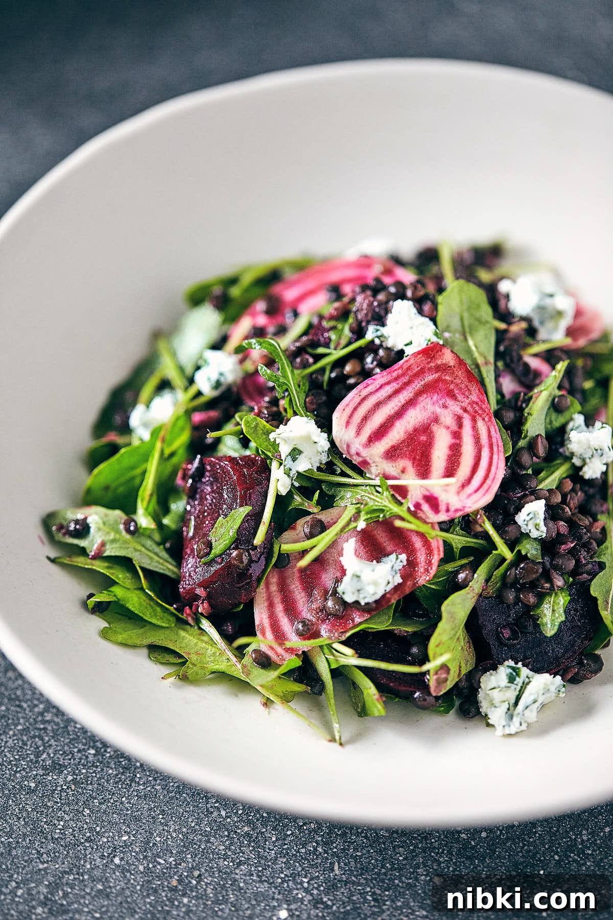 Roasted Beet and Lentil Salad with Herbed Goat Cheese 2 Close up of beet and lentil salad in a white bowl