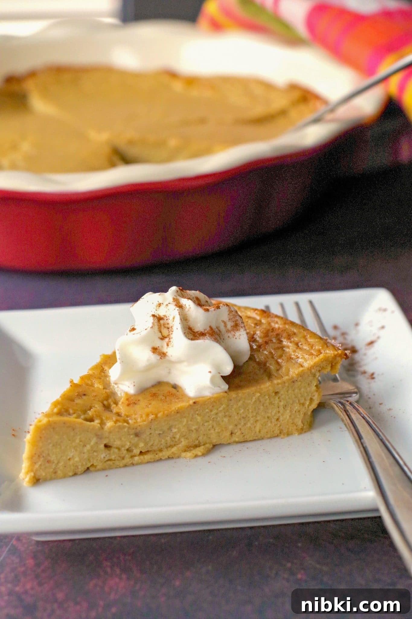 Crustless Pumpkin Pie for Weight Watchers 8 WW no crust pumpkin pie on a white plate with fork and whole pie in background