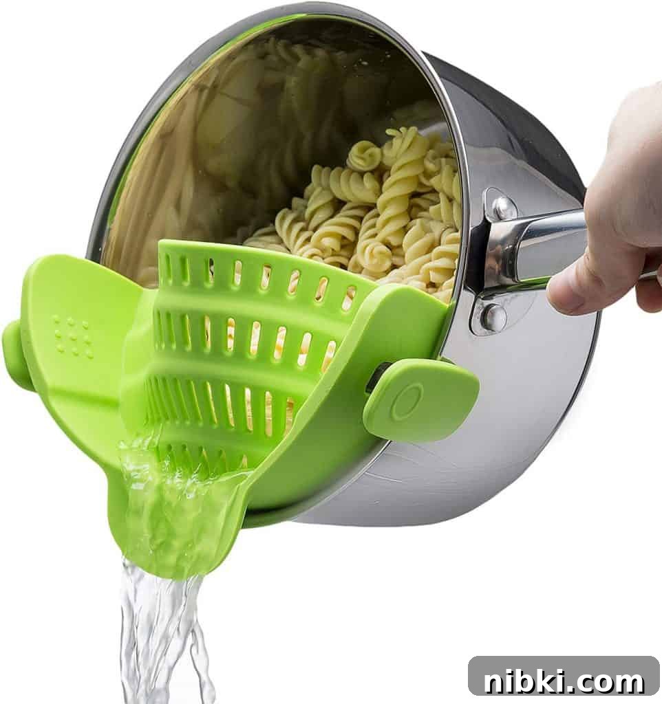 8 Small Kitchen Accessories That Save Space on Amazon 3 Pot strainer clipped to a saucepan for draining pasta