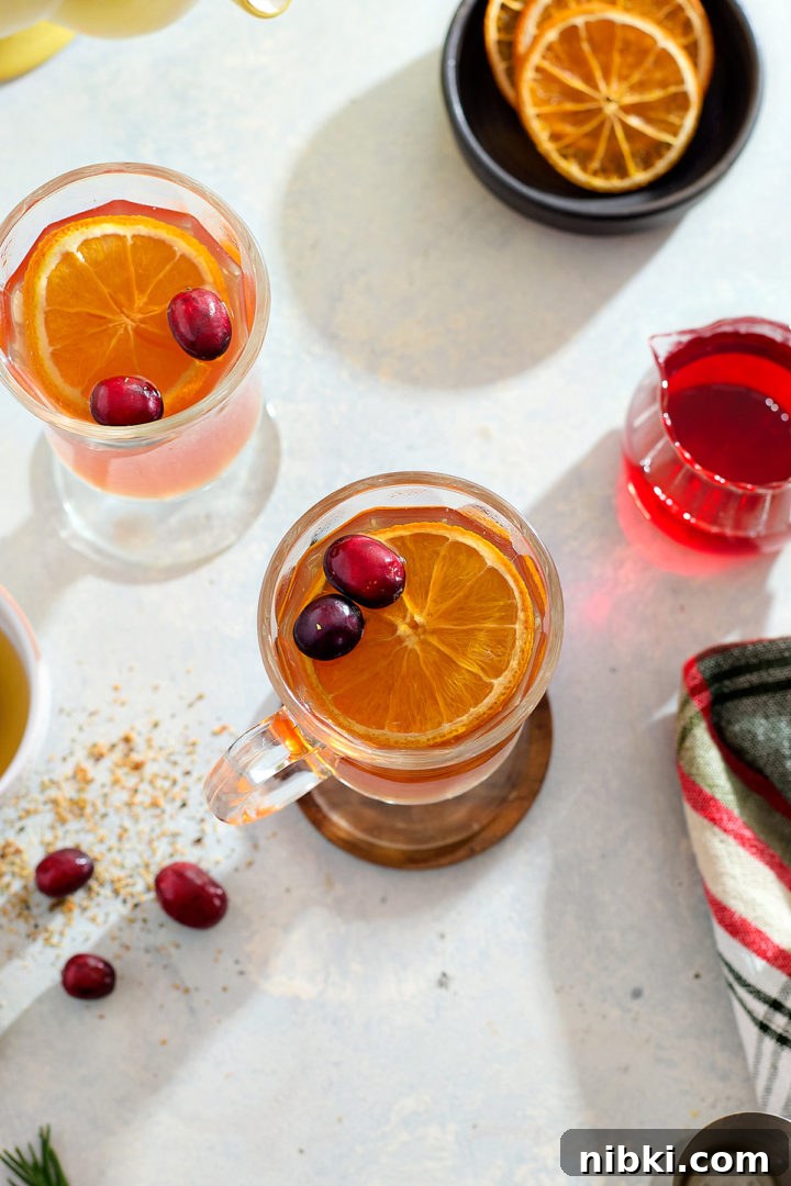 A cranberry hot toddy in a glass mug.