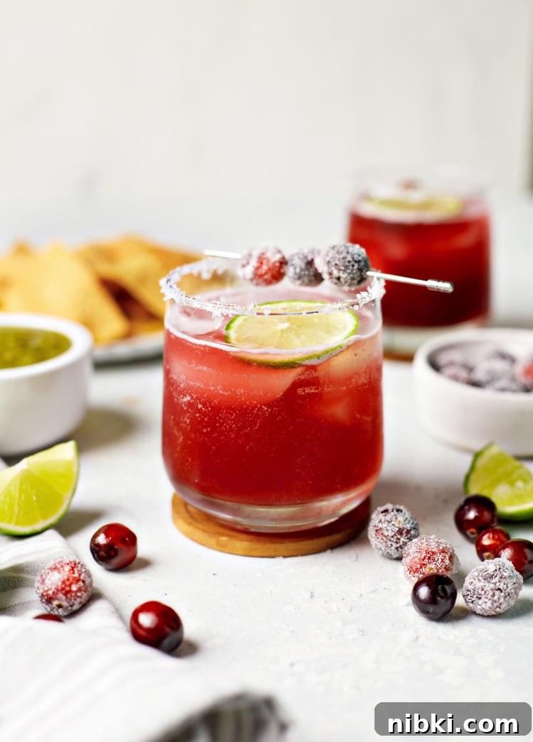 glasses of cranberry margaritas with lime and cranberry garnish