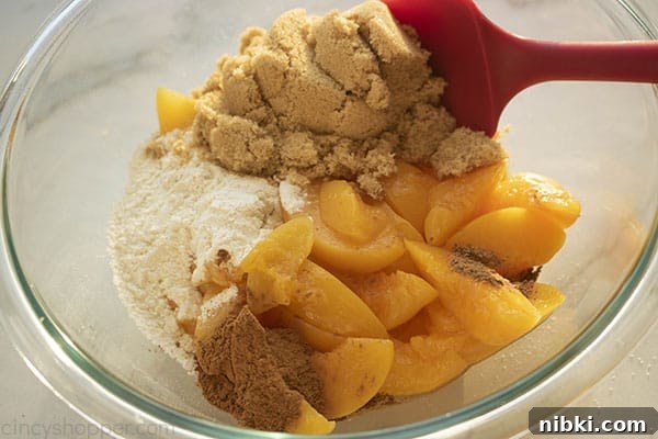 Peach Cobbler Recipe with Golden Biscuit Topping 5 Sugar, flour, cinnamon, nutmeg and peaches in a mixing bowl