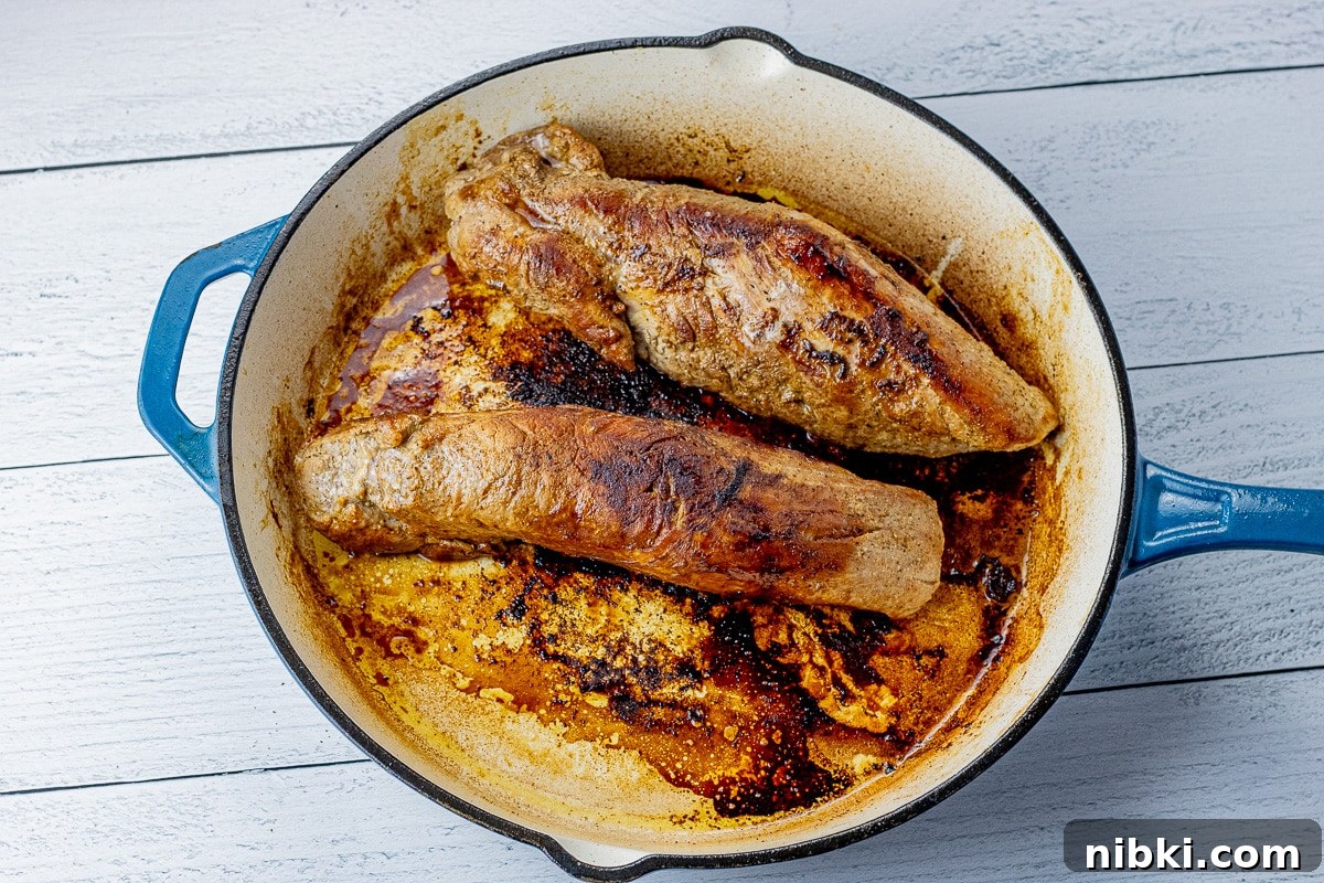 two pork tenderloins browned in a cast iron pan
