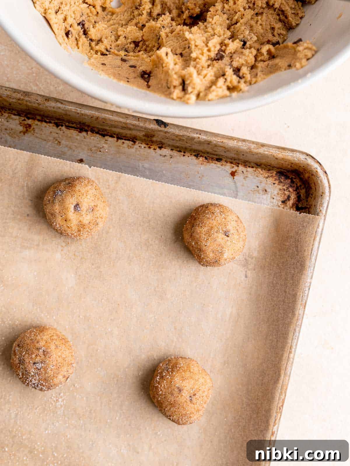 Browned Butter Snickerdoodles with Cinnamon Sugar 8 Snickerdoodle cookie dough balls on a baking sheet.
