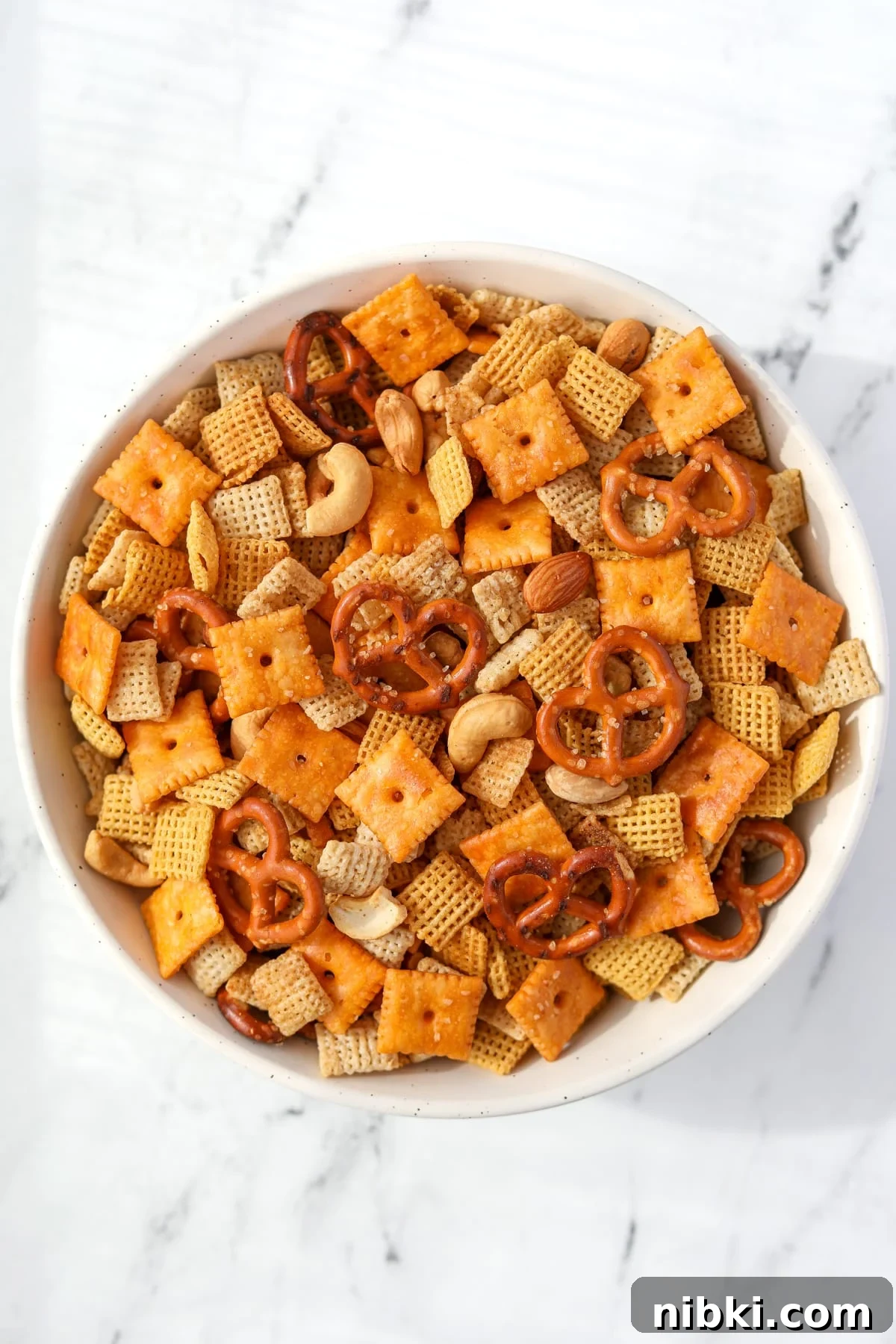 Homemade Chex Mix: Savory Snack Mix Recipe 9 A bowl of Chex Mix on a white background.